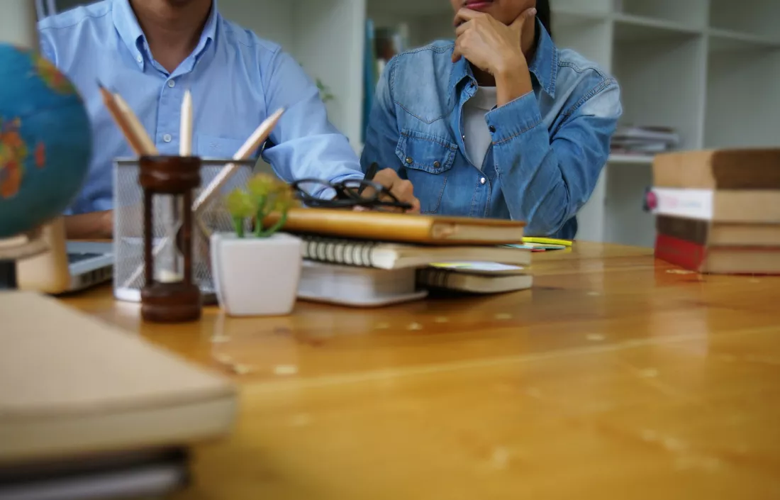 midsection-colleagues-sitting-desk-office