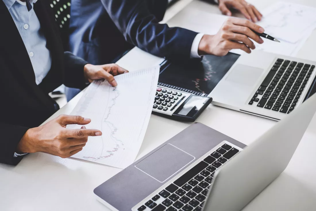 midsection-business-colleagues-discussing-desk-office